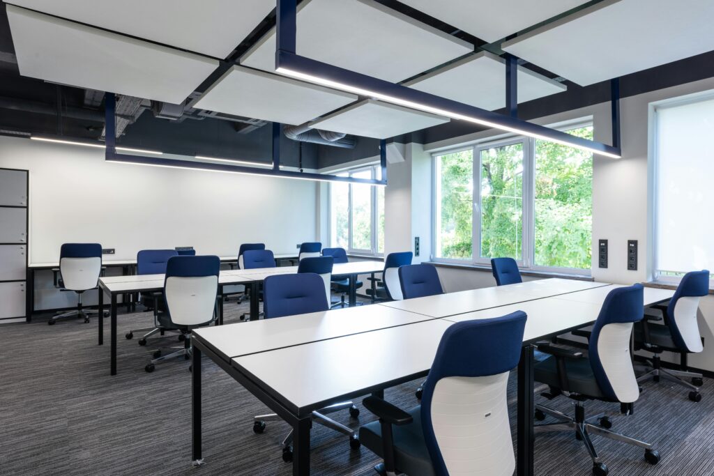 Spacious, modern office interior with blue chairs and ample natural light.